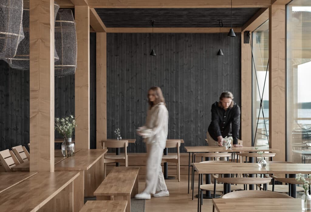 A restaurant team preparing a light-filled dining room for guests